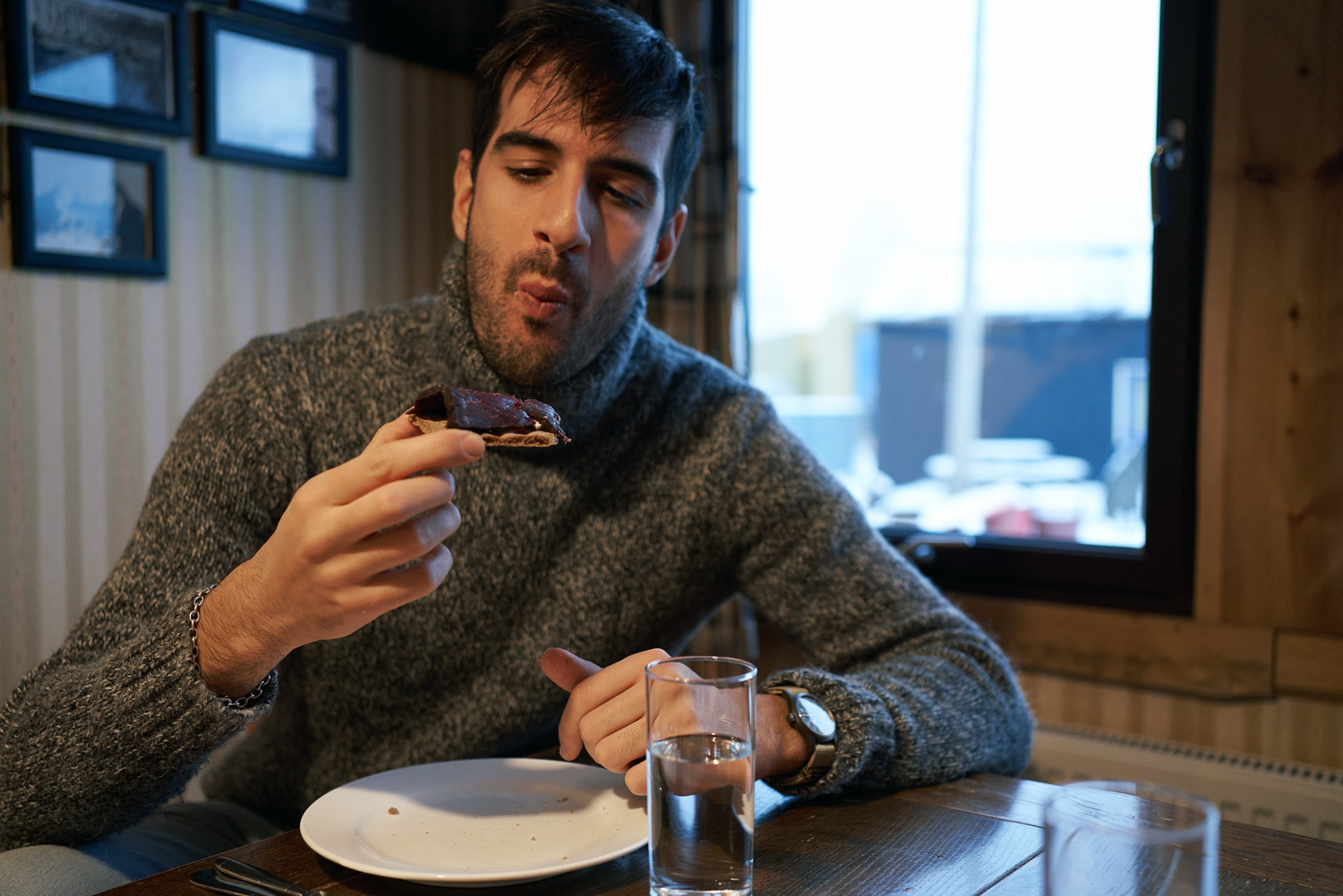Arctic cuisine, Svalbard, Nick Casini - Man in grey jumper eating whale meat.