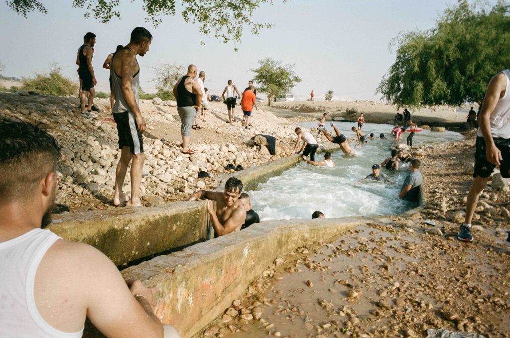Palestinians take a dip in a natural spring on a hot day. Jericho, Palestine